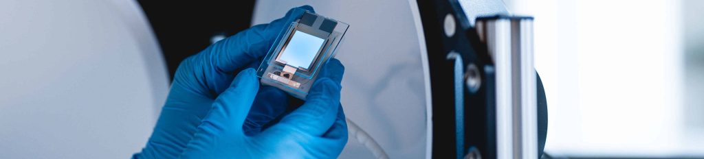 hands in blue gloves holding a high-performance chip